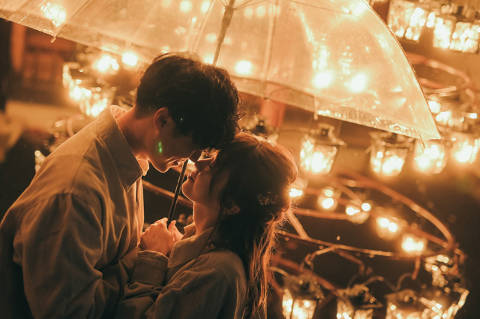 傘をさして向き合う男女